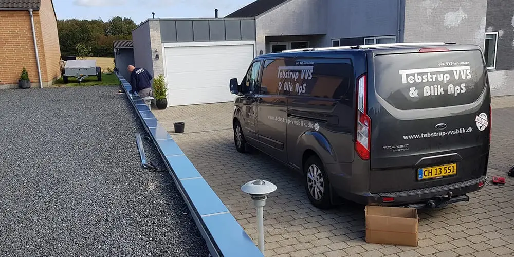 Blikarbejde langs en indkørsel med servicebil fra Tebstrup VVS & Blik